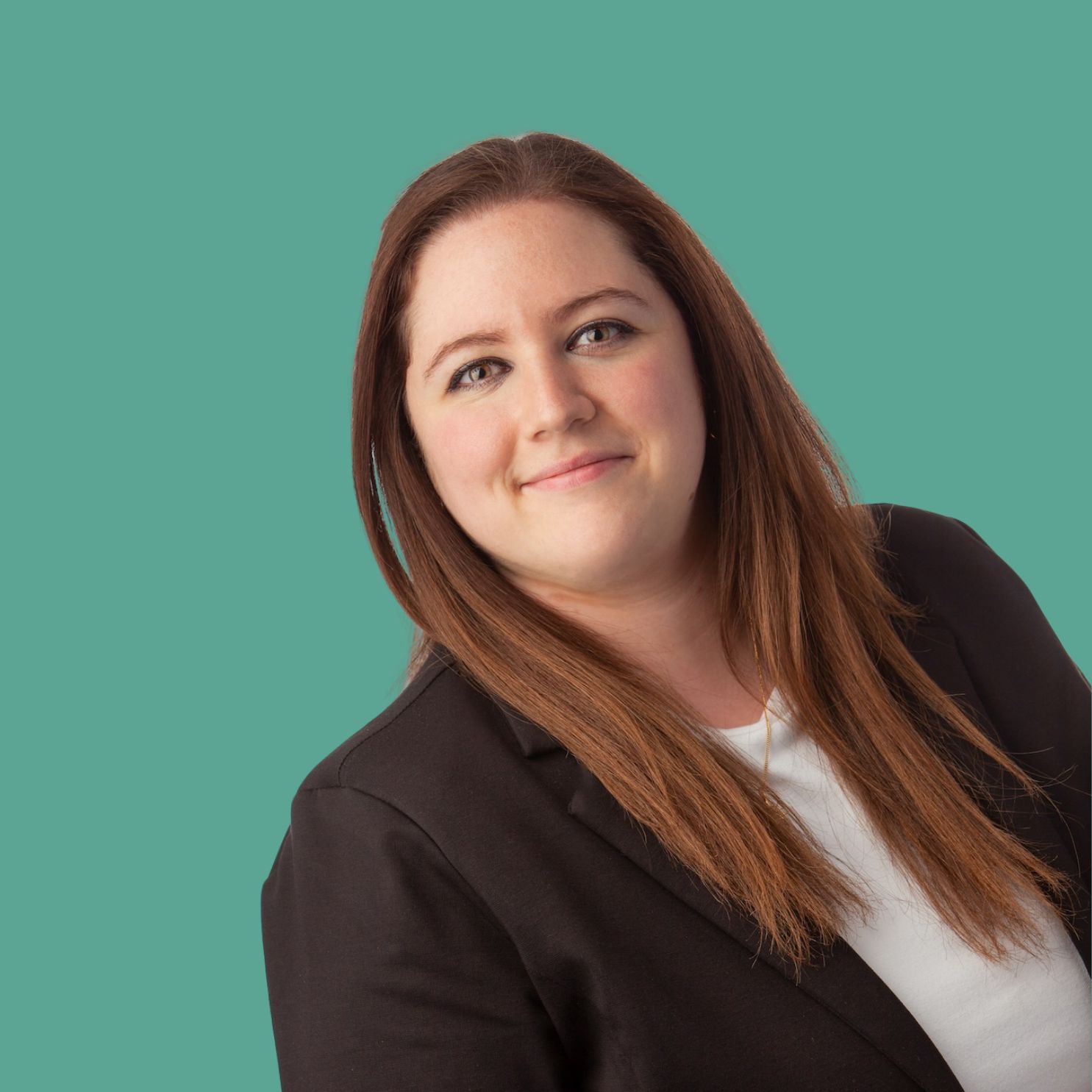 Porträt einer freundlichen, brünetten Frau, die ein weißes Shirt und einen schwarzen Blazer trägt. Der Hintergrund ist grün/türkis.